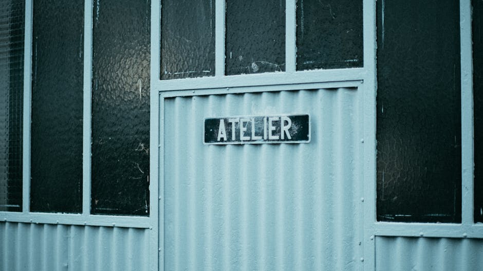 Rustic workshop entrance with 'atelier' sign, showcasing vintage industrial design.